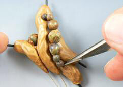 Beaded wire being pressed into clay